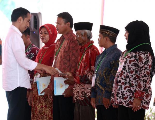 Presiden Jokowi saat menyerahkan 1989 sertifikat tanah, di Lapangan Ranggajati, Kecamatan Sumber, Kabupaten Cirebon, Kamis (13/4). (Ist)